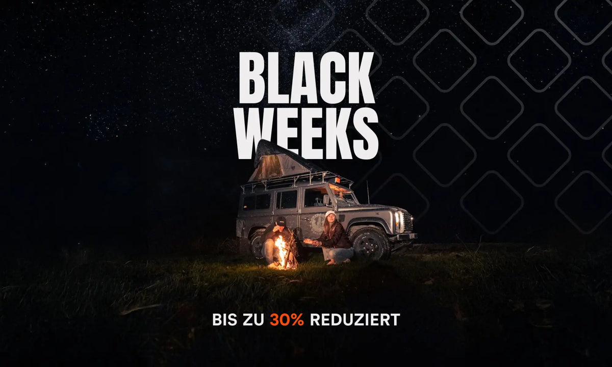 2019 Land Rover Defender 130 mit Dachzelt und Lagerfeuer.