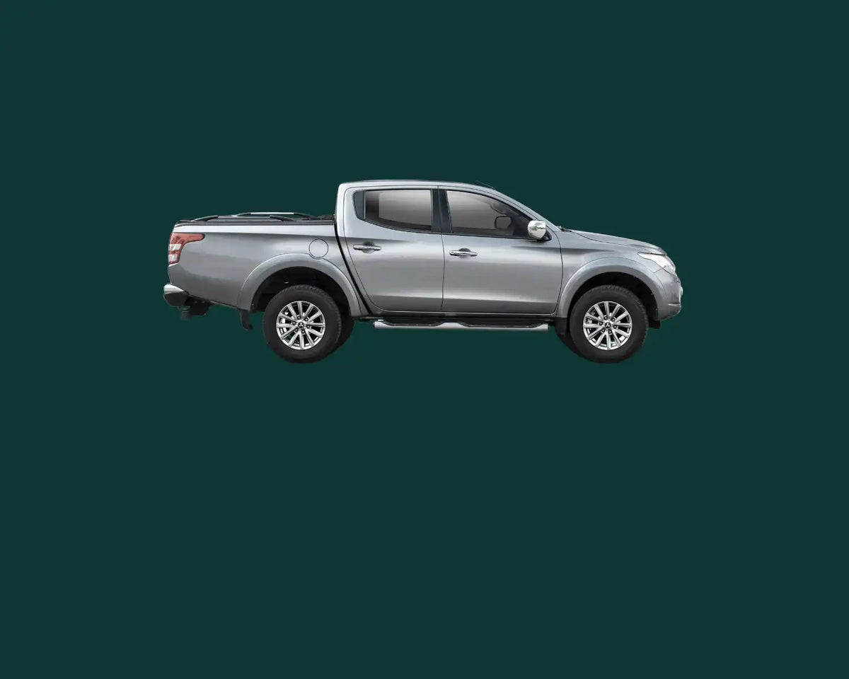 Silberner Mitsubishi Triton Pickup-Truck im Seitenprofil.